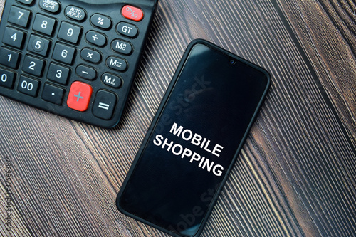 Mobile Shopping write on Smartphone isolated on office desk.