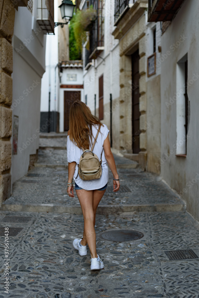 Shallow focus shot of a young female in an old city street