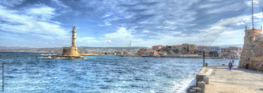 A view along a breakwater towards an inner harbour in Chania, Crete on a bright sunny day