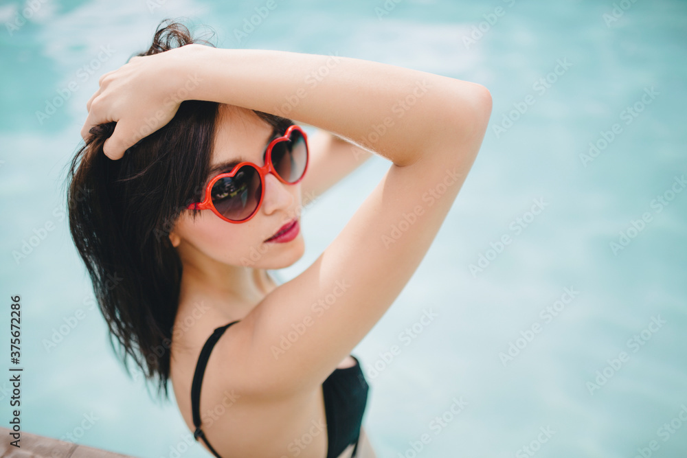 A beautiful woman with her arms up in the pool A beautiful woman with her arms up in the pool