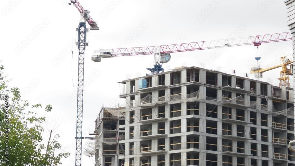 Working tall cranes inside place for with tall buildings under construction under a blue sky Working tall cranes inside place for with tall buildings under construction under a blue sky