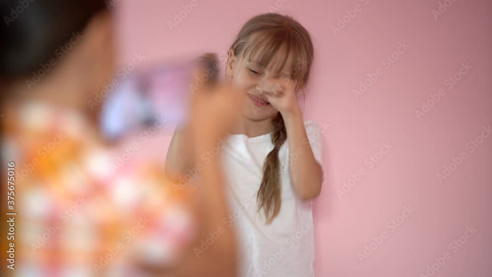 custom made wallpaper toronto digitalTwo funny cute girls sisters learning using smartphone taking selfie at home, lenjoy social media app play game on a pink background, children and technology concept