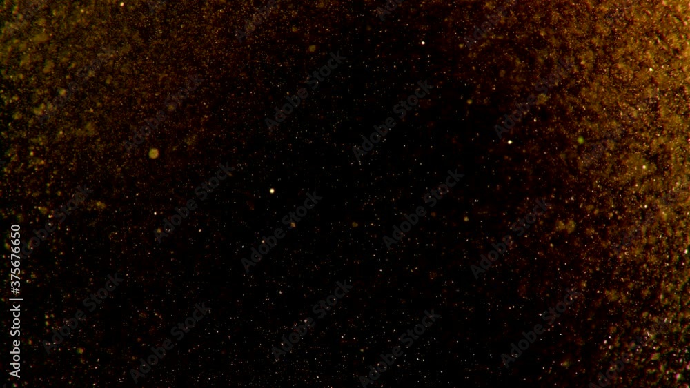 Abstract particles of gold liquid flow and float motion on black Abstract particles of gold liquid flow and float motion on black