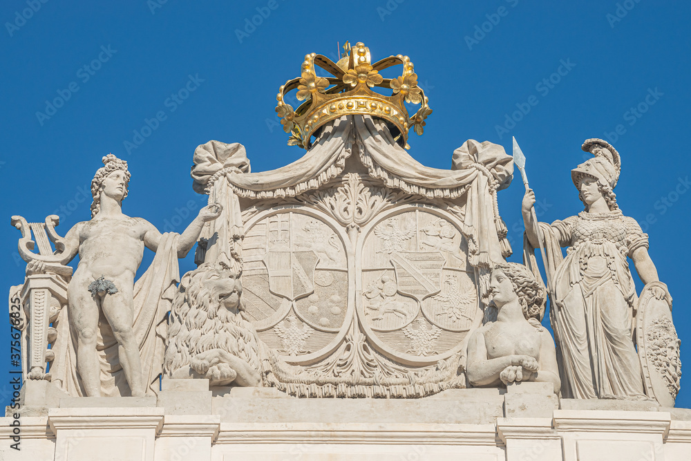 Roof statues of Imperial symbols and coat of arms at Alberina museum, near Palmenhaus and Neue Burg Palace garden in historical downtown of Vienna, Austria