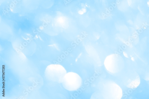 Bokeh light on blue background, sky with circle glitter light blue. Snow abstract soft glowing with vivid bright light and bokeh blur effect. 