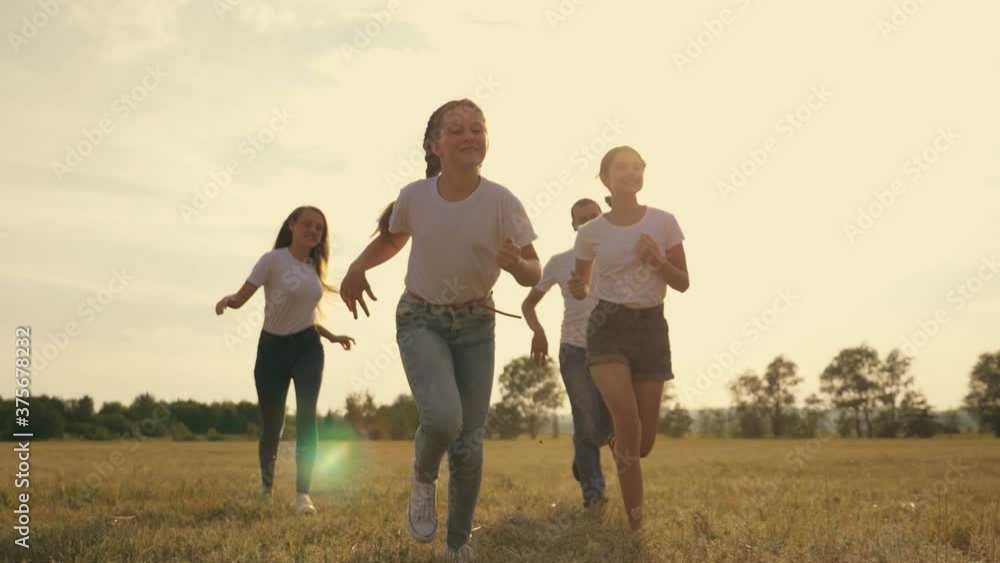 Happy family in the team mom dad children, kids run together in the park at sunset, silhouette groups of people in the park, parents and daughters cheerfully run through the grass on vacation. Team. Happy family in the team mom dad children, kids run together in the park at sunset, silhouette groups of people in the park, parents and daughters cheerfully run through the grass on vacation. Team.