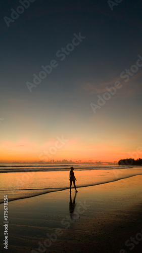 young woman exercising on the beach at beautiful sunset