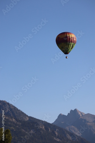 Hot air balloon in between two mountains. 