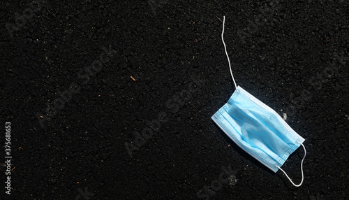 Blue Disposable Fask Mask On Black Asphalt photo