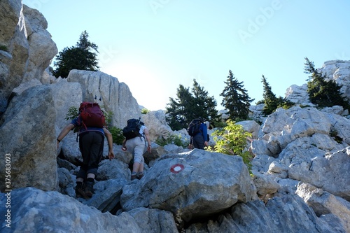 The beautiful Premuziceva Staza mountain path, Velebit National Park, Dinaric Mountains, Croatia. Silhouette of climbing tourists among rocks. photo