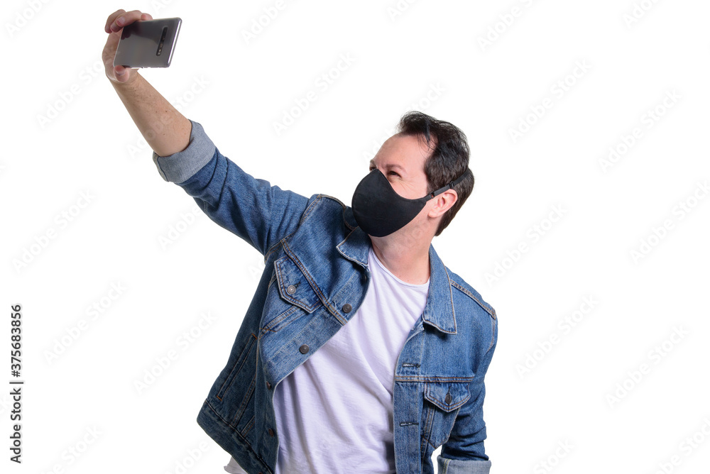 Young brazilian man using medicine healthcare mask for health medical care, protect Covid-19, with cellphone making selfie isolated on white Young brazilian man using medicine healthcare mask for health medical care, protect Covid-19, with cellphone making selfie isolated on white