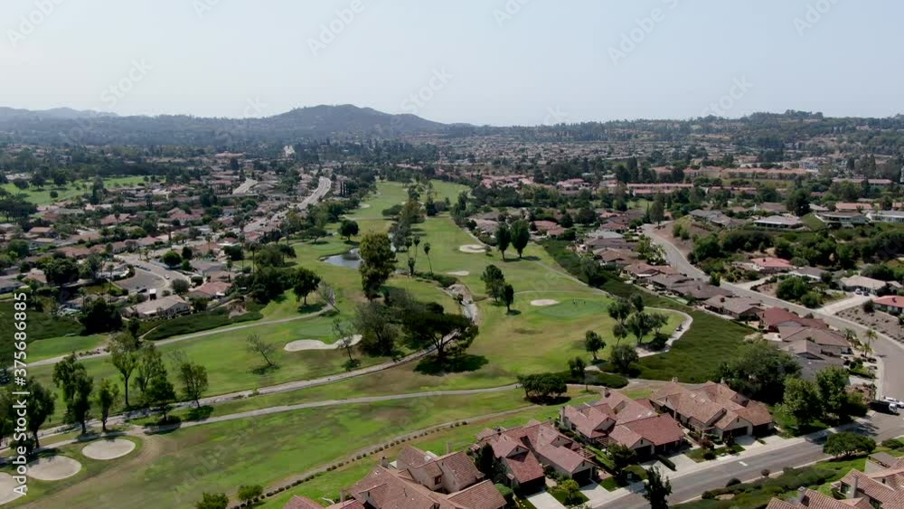 Aerial view of golf in middle class neighborhood surrounded with residential house, and mountain on the background in San Diego, South California, USA. Aerial view of golf in middle class neighborhood surrounded with residential house, and mountain on the background in San Diego, South California, USA.