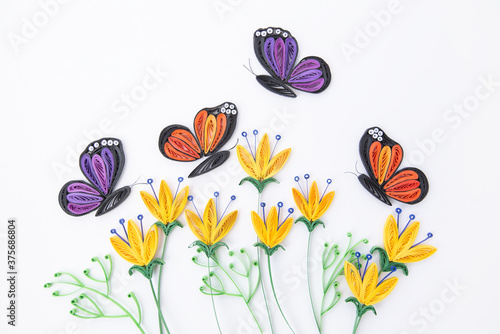 Beautiful butterflies and yellow flowers, isolated on white background. Hand made of paper quilling technique. © Cristina
