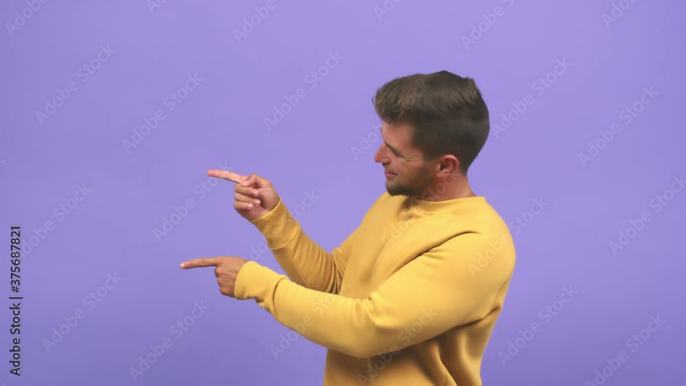 Young caucasian handsome man pointing to the side, smiling surprised presenting something, natural and casual Young caucasian handsome man pointing to the side, smiling surprised presenting something, natural and casual