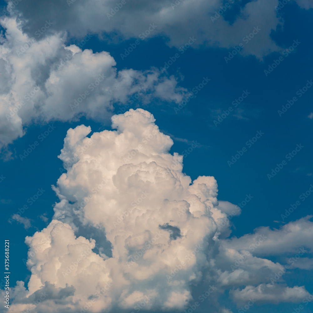 beautiful blue sky with white large cumulus cloud in the foreground as a natural background