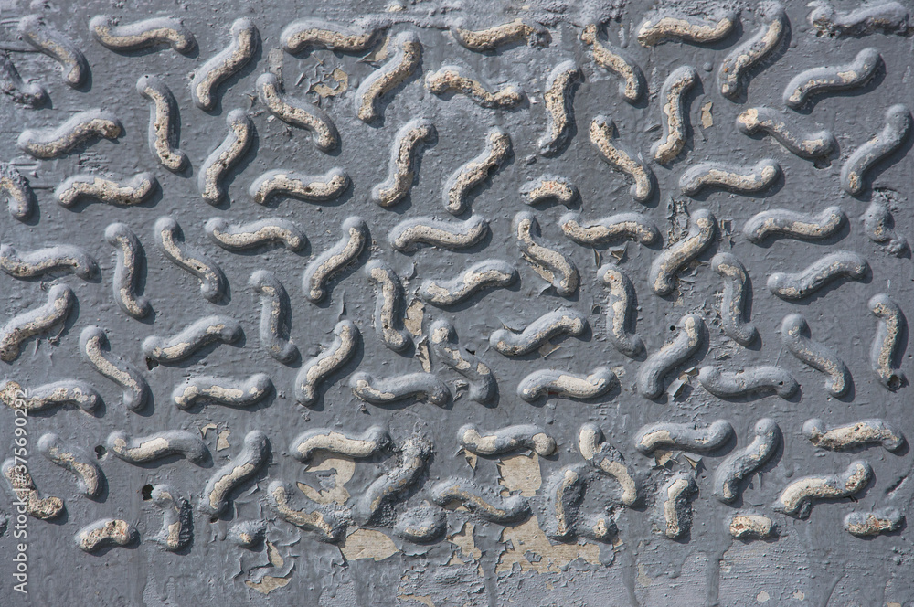 Texture of an old gray wall of a building with an abstract pattern, cracks and smudges close-up.