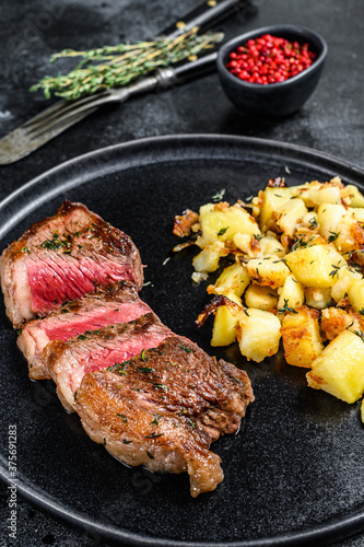 Grilled Striploin steak with potato, beef meat. Black background. Top view