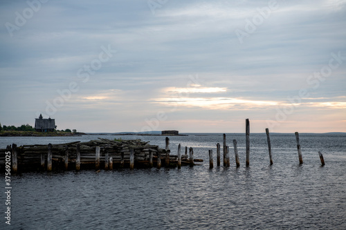 beautiful landscape with old wooden port, stones and sea at sunrise © константин константи
