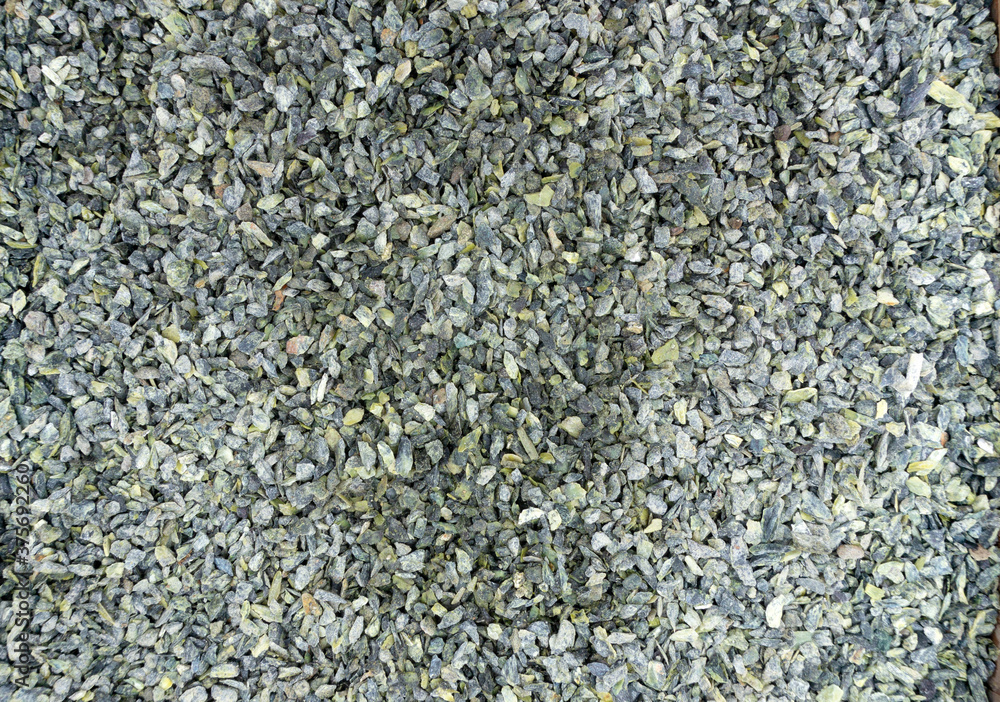 Serpentine stone chips. Green background from serpentine crumbs. Small green stones texture. Decorating the garden with decorative natural stone. Serpentine stone chips. Green background from serpentine crumbs. Small green stones texture. Decorating the garden with decorative natural stone.