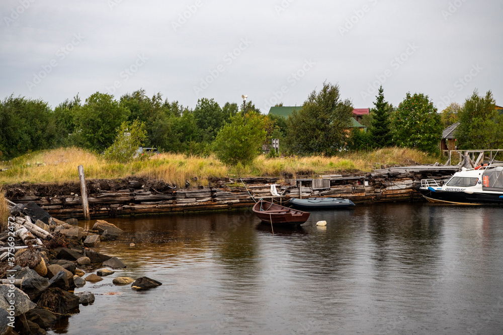 beautiful landscape with old wooden port, stones and sea at sunrise