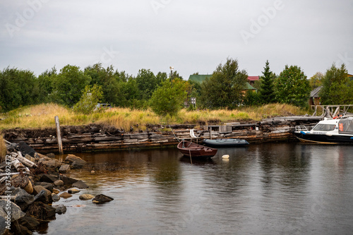 beautiful landscape with old wooden port, stones and sea at sunrise