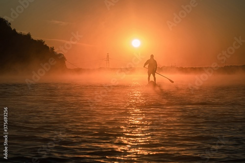 man paddling on the river in fog
