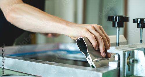 Fotografia Cropped view of artisan working on screen printing machine with squeegee