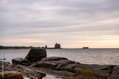 beautiful landscape with old wooden port, stones and sea at sunrise