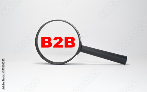 B2B inscription in a magnifying glass on a boundless white background