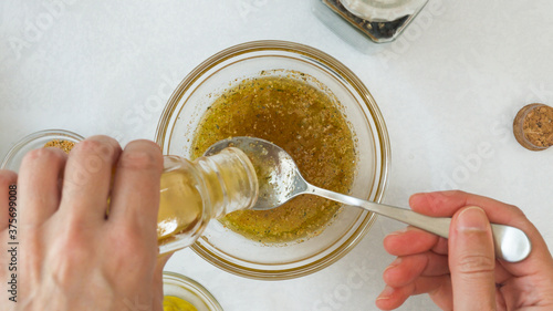 Foto Salad dressing ingredients, as olive oil, honey, lemon juice, seasoning, mustard and black pepper
