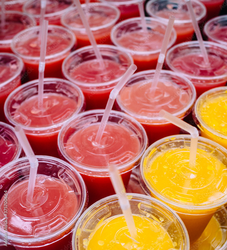 Rows of strawberry and orange juice drinks Rows of strawberry and orange juice drinks