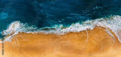Fototapeta Naklejka Na Ścianę i Meble -  Beautiful sandy beach, top view. Panoramic view of the sandy beach. The sea wave rolls on the shore. Sea coast view from the air. Aerial photography of the sea wave. The ocean and beach. Copy space