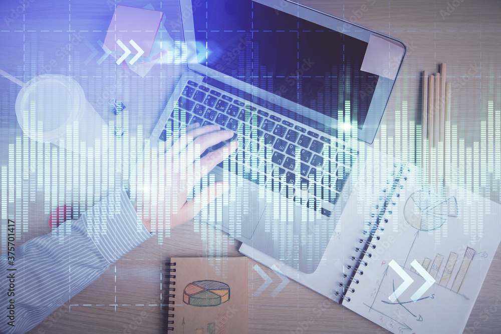 Double exposure of man's hands typing over computer keyboard and forex graph hologram drawing. Top view. Financial markets concept. Double exposure of man's hands typing over computer keyboard and forex graph hologram drawing. Top view. Financial markets concept.