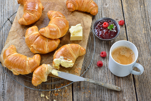 Bild auf Leinwand Rustikales Croissant-Frühstück mit Butter, Marmelade und einem Haferl Kaffee Crè