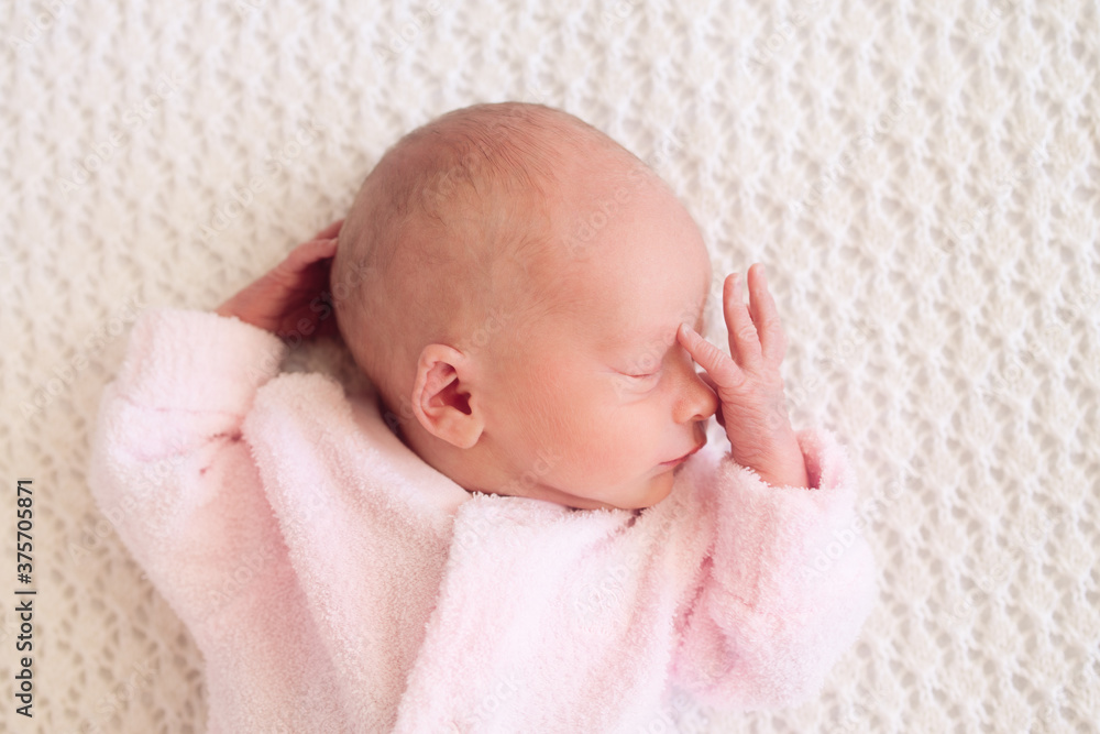 Newborn baby girl asleep with her hands on her head Newborn baby girl asleep with her hands on her head