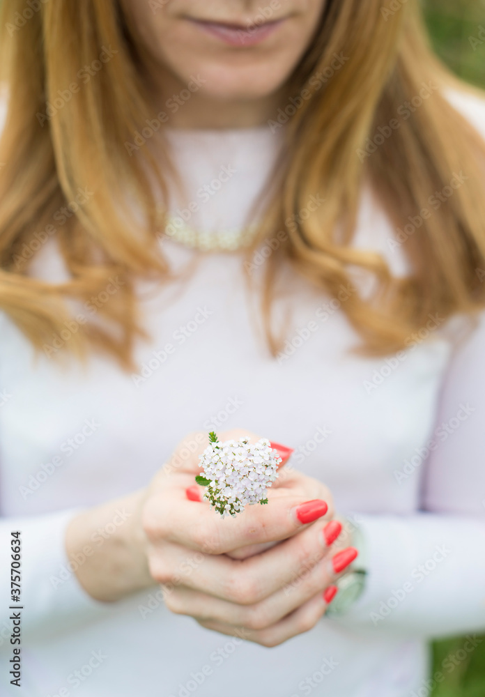 A red haired woman holding a flower. A red haired woman holding a flower.