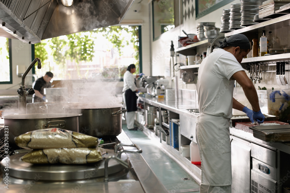 Big restaurant kitchen and cooks preparing food Big restaurant kitchen and cooks preparing food