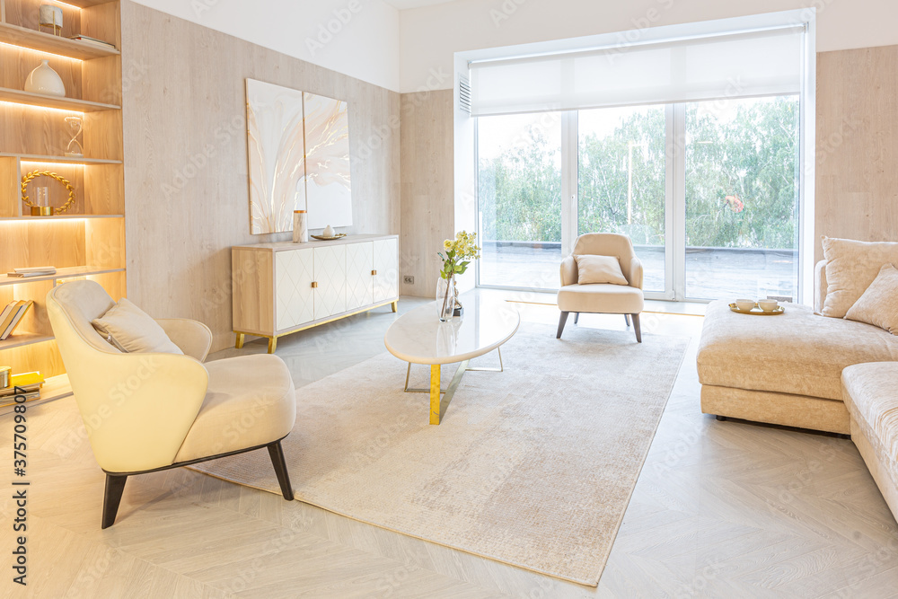 Fototapeta premium modern interior design of the living area in the studio apartment in warm soft colors. decorative built-in lighting and soft beige furniture