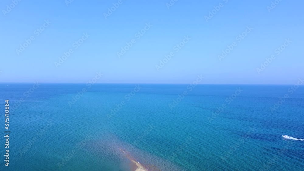 Speedboat sailing on blue tranquil sea and passing next to exotic sandbank beach. Aerial view Speedboat sailing on blue tranquil sea and passing next to exotic sandbank beach. Aerial view