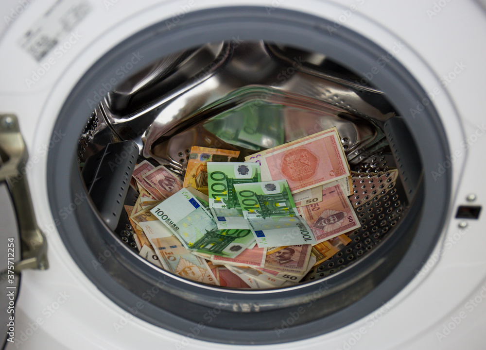 A pile of dirty money in a clothes machine. washing steam in the drum of the washing machine A pile of dirty money in a clothes machine. washing steam in the drum of the washing machine