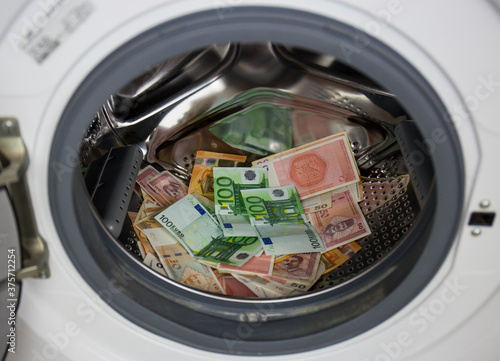 A pile of dirty money in a clothes machine. washing steam in the drum of the washing machine © HappyLenses