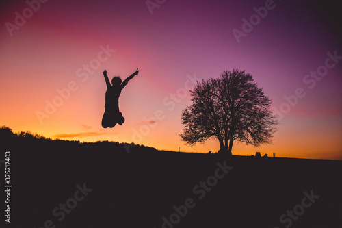 Girl Jumps so high with sunset in the background
