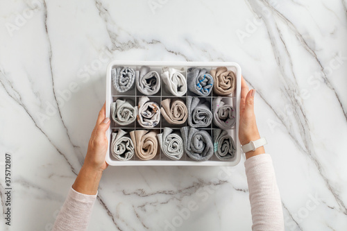 Fényképezés Woman hands placing organizer drawer divider with full of folded underwears and socks