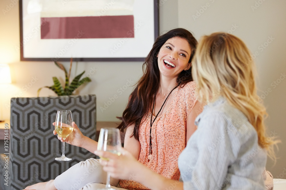 Girlfriends relaxing with wine in luxury hotel room. Girlfriends relaxing with wine in luxury hotel room.