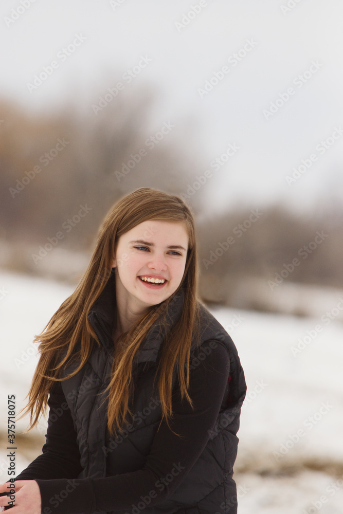 Teen smiling while preparing to throw snowballs Teen smiling while preparing to throw snowballs
