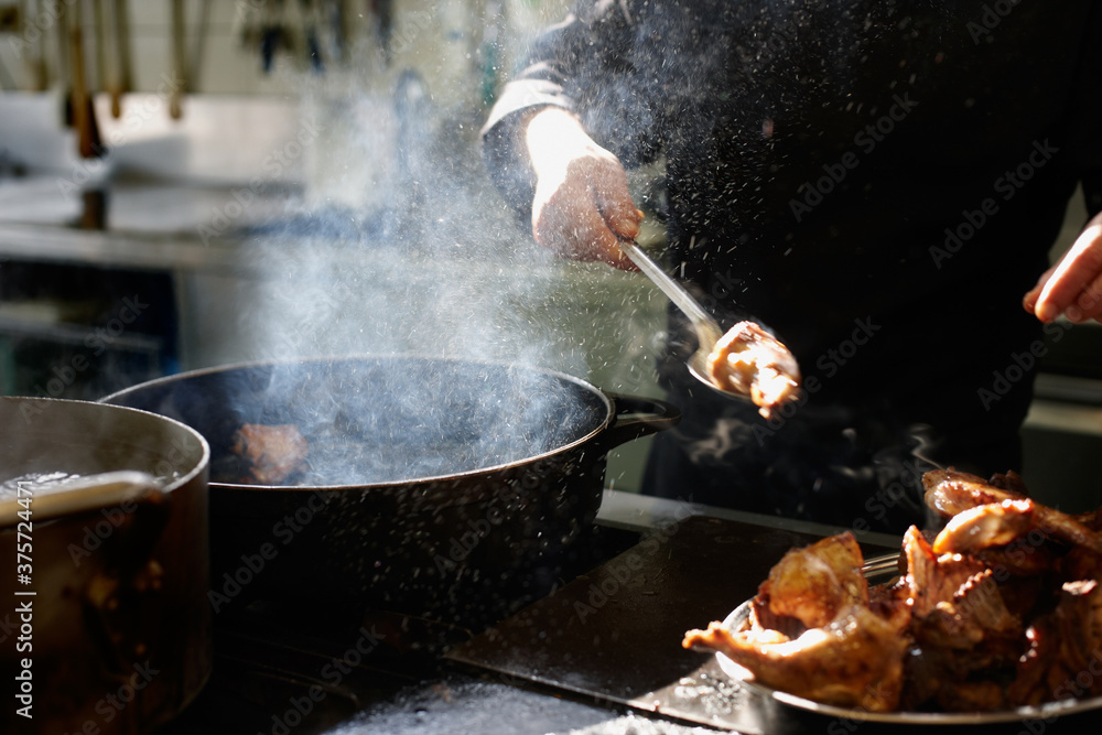 Close up of a chef frying some meat with hot oil Close up of a chef frying some meat with hot oil