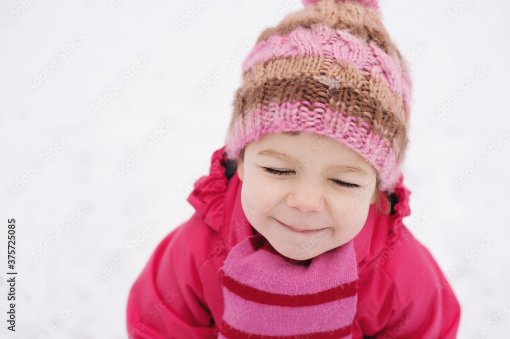Little girl enjoying her time spent outdoors in snowy weather with her eyes closed. Little girl enjoying her time spent outdoors in snowy weather with her eyes closed.