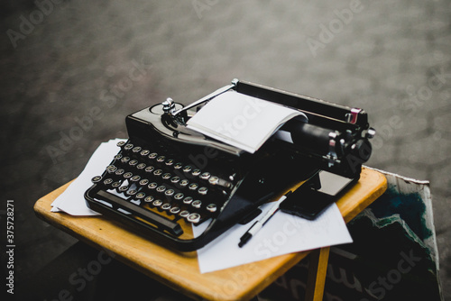 Black typewriter with empty pages outside photo