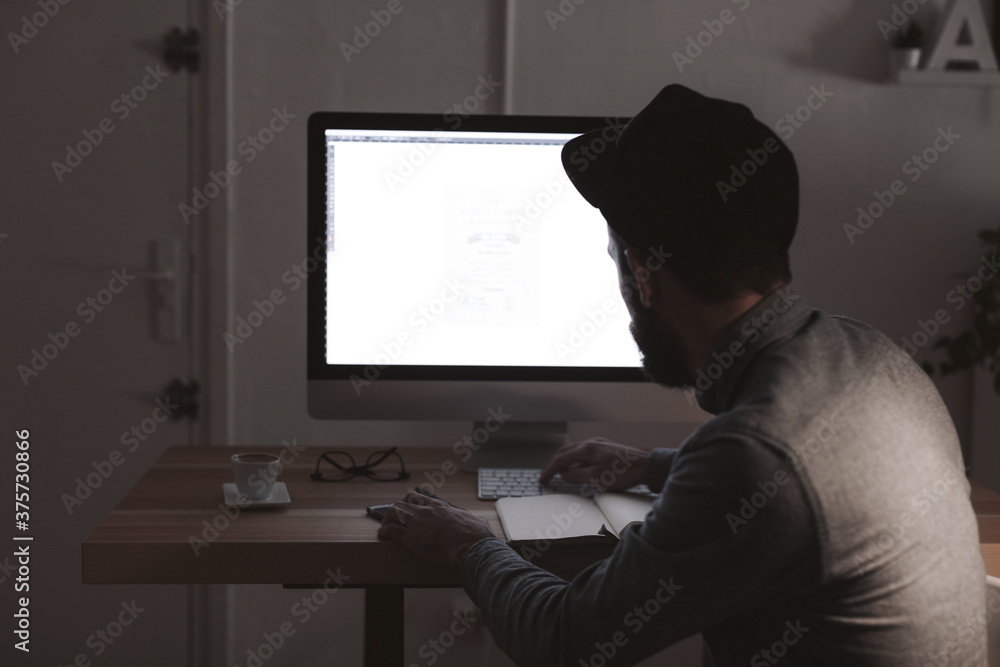 Young graphic designer working in his office at afternoon. Young graphic designer working in his office at afternoon.