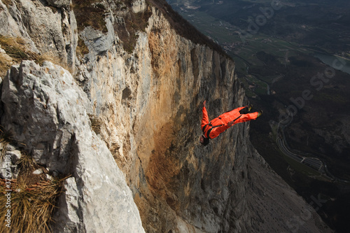 Basejumper exiting from a cliff performing a backflip